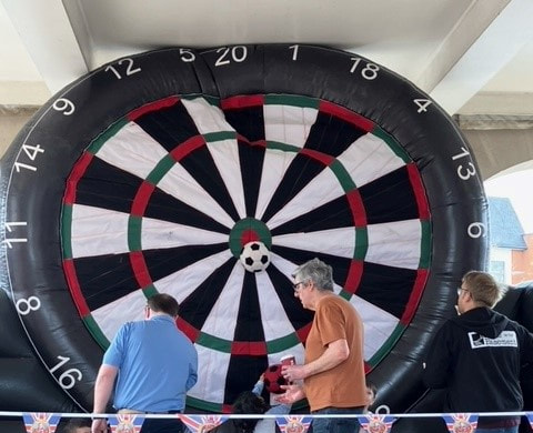 Image shows House in the Basements inflatable dartboard being used at Sevenoaks Clock tower to Commemorate the Coronation of King Charles III.